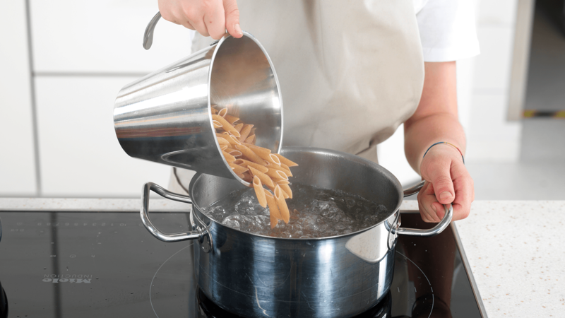 Ha pasta i det kokende vannet og rør rundt med en sleiv. Skru ned varmen til middels, slik at det ikke koker over.
