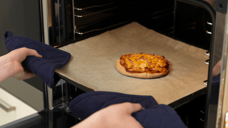 Finn frem en rist eller noe du kan sette det varme stekebrettet på. Bruk grytekluter og pass på, slik at du ikke brenner deg når du tar ut pitapizzaen.