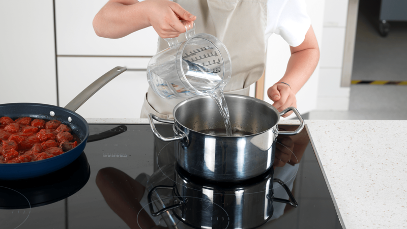 Sett en stor kjele på kokeplaten, bruk et desilitermål eller en mugge og fyll kjelen halvfull med vann. Skru platen på fullt.