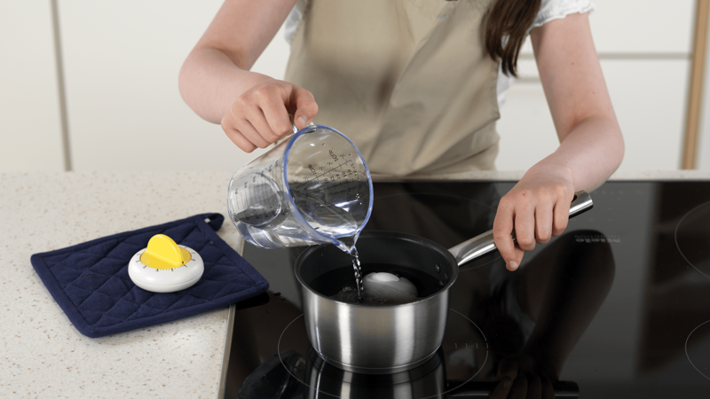 Sett en kjele på kokeplaten. Legg egg i kjelen og hell over vann, til det dekker eggene. Bruk et målebeger, eller noe annet du har på kjøkkenet.