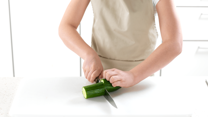Vask agurk. Skjær av den mengden agurk du trenger og del agurkbiten i to. Bruk klogrepet, som vist på bidet, slik at du ikke skjærer deg.