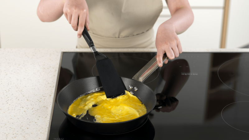Når eggerøren begynner å stivne, skyv den inn mot midten av pannen med en stekespade.