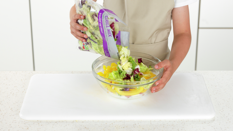 Åpne posen med salat og hell innholdet over i bollen.