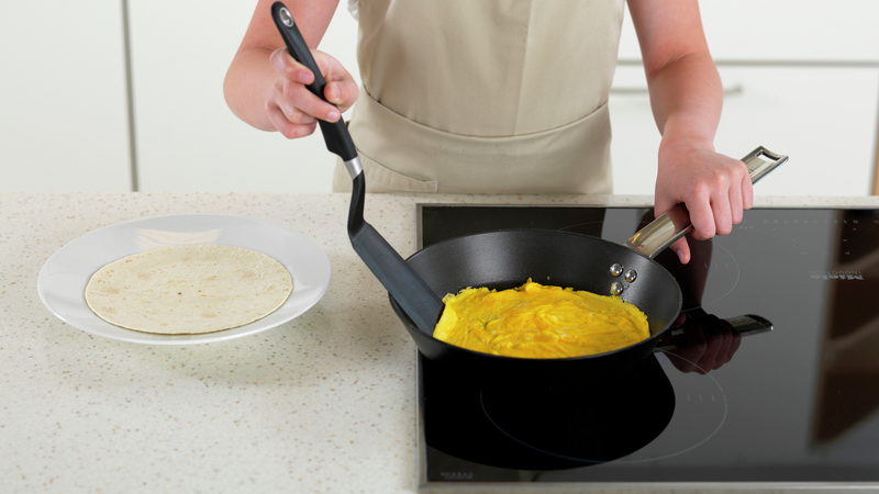 Legg en hvetetortilla på en tallerken. Når omeletten begynner å bli ferdig, trekk stekepannen til side. La den stå i 1 min for å stivne helt.