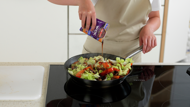 Klipp opp posen med woksaus og hell sausen over.