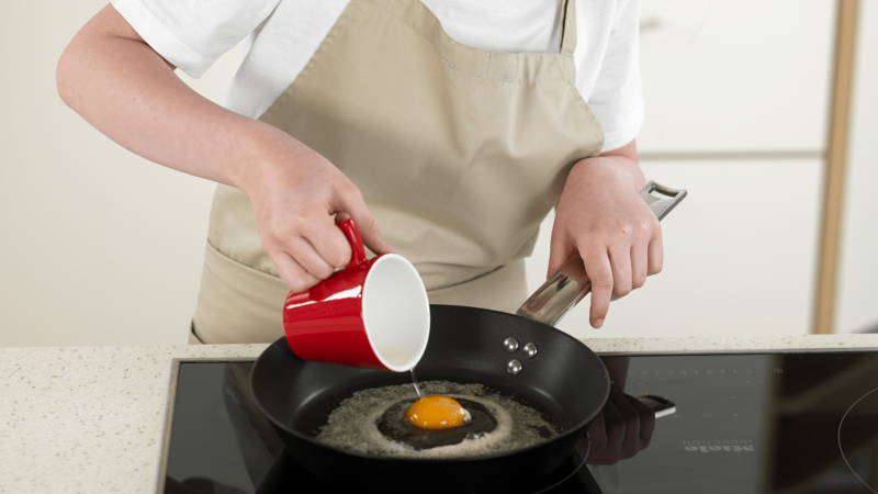 Når margarinen slutter å bruse, kan du forsiktig helle egget over i stekepannen.
