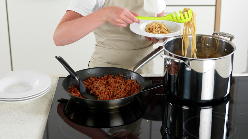 Fordel pasta i dype tallerkener med en pastasleiv.