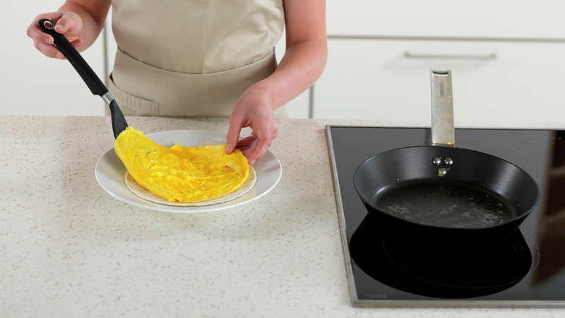 Legg forsiktig omeletten over hvetetortillaen.