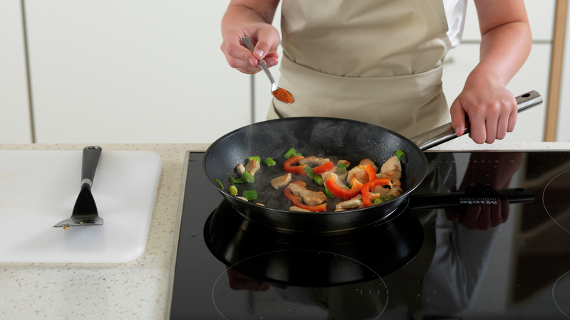 Ha i tandoorikrydder. Rør med stekespaden slik at krydderet blandes med kyllingen og grønnsakene.